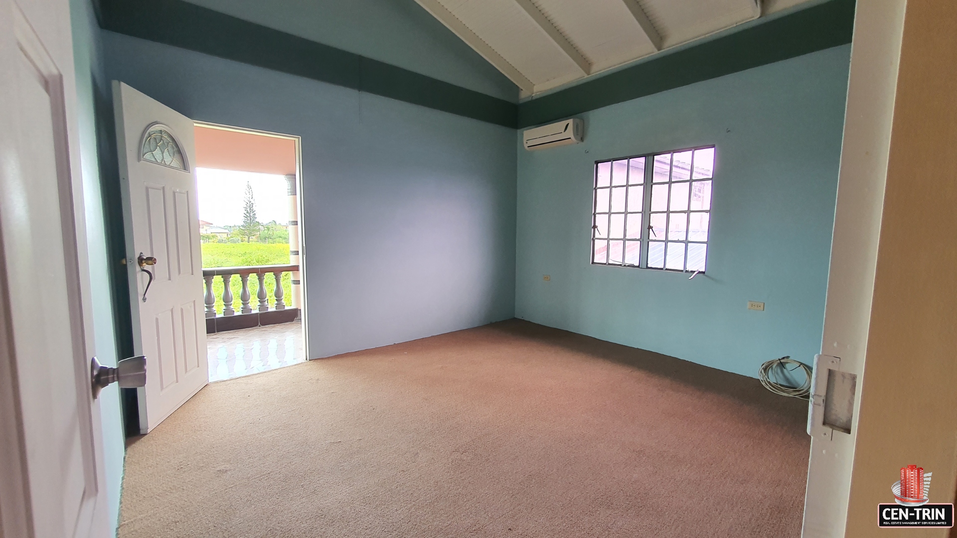 A charming room with a wooden door and a window with a white curtain.
