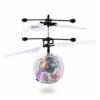 A clear, induction flying toy with colorful confetti inside, levitating and spinning in mid-air.