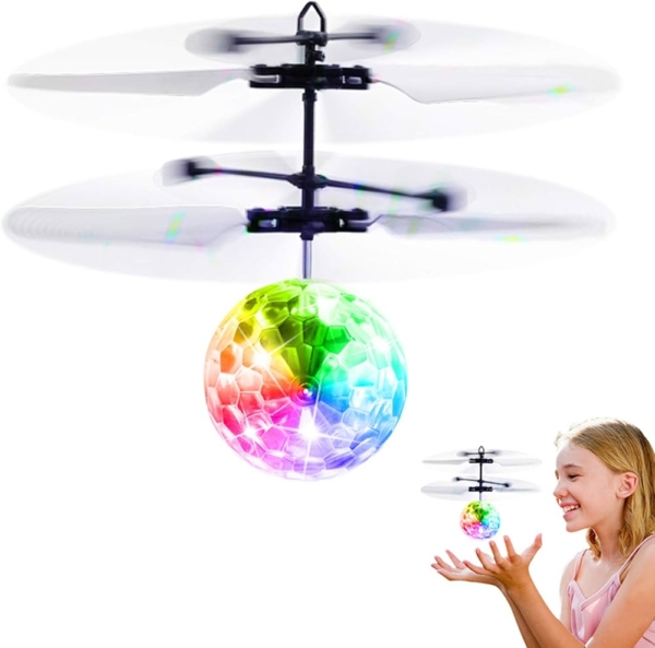 A hand controlling a flying ball toy with flashing LED lights, hovering in mid-air.