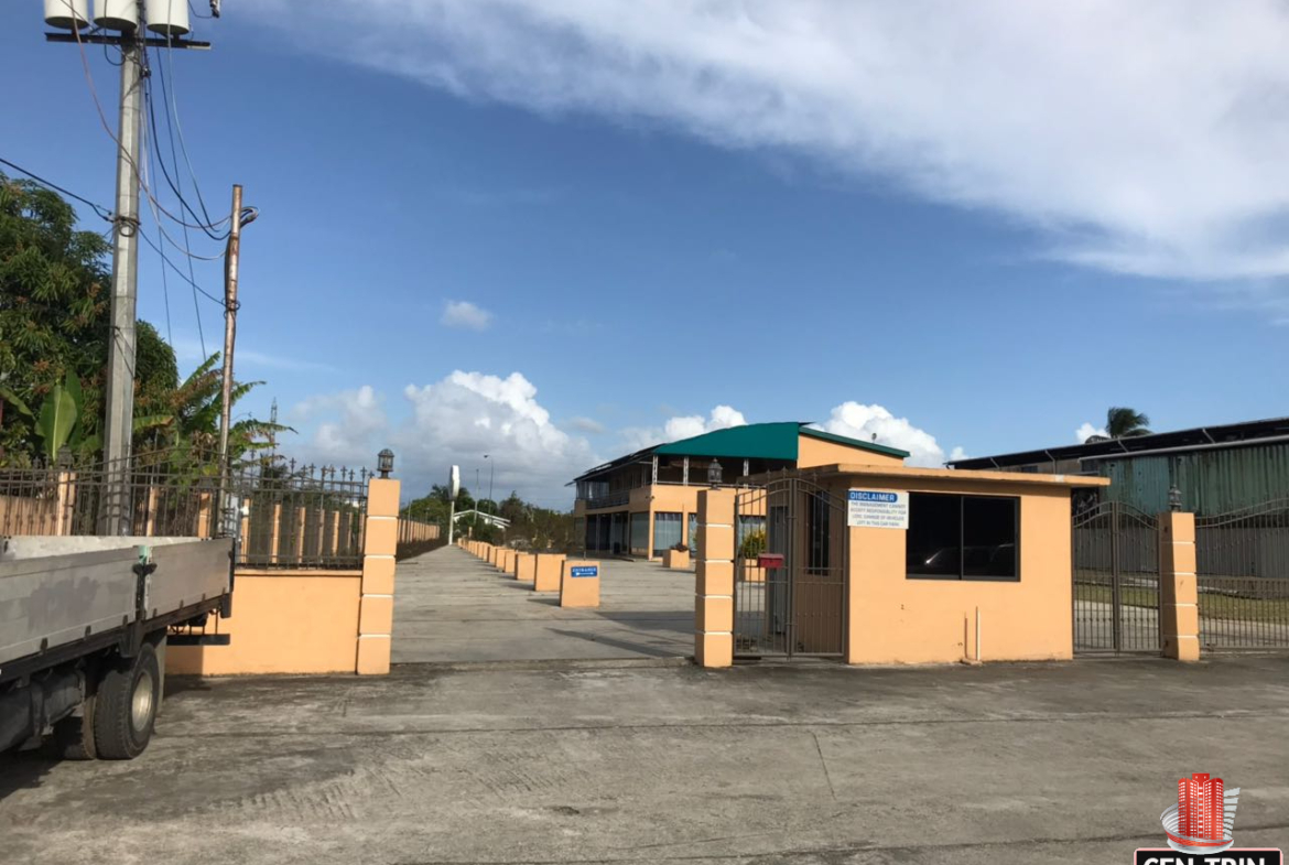 commercial building for sale with exterior view of a commercial building in Calcutta Freeport, Trinidad, showcasing ample parking space.