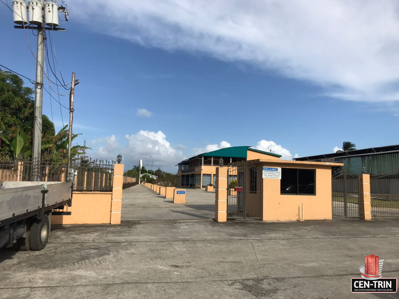 commercial building for sale with exterior view of a commercial building in Calcutta Freeport, Trinidad, showcasing ample parking space.