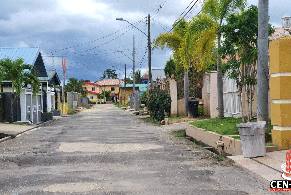 A view down a residential street in Krystal Gardens, Freeport, showing existing homes, paved road, and utility poles, providing context for the land for sale in Trinidad within this established community.