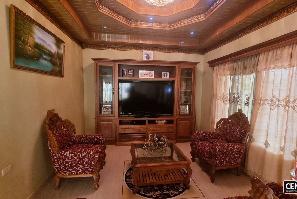 Elegant entertainment area with wooden unit and comfortable seating in this luxury home for sale in Cunupia