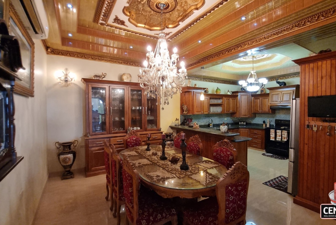 Elegant formal dining room open to a modern internal kitchen in this luxury home for sale in Cunupia