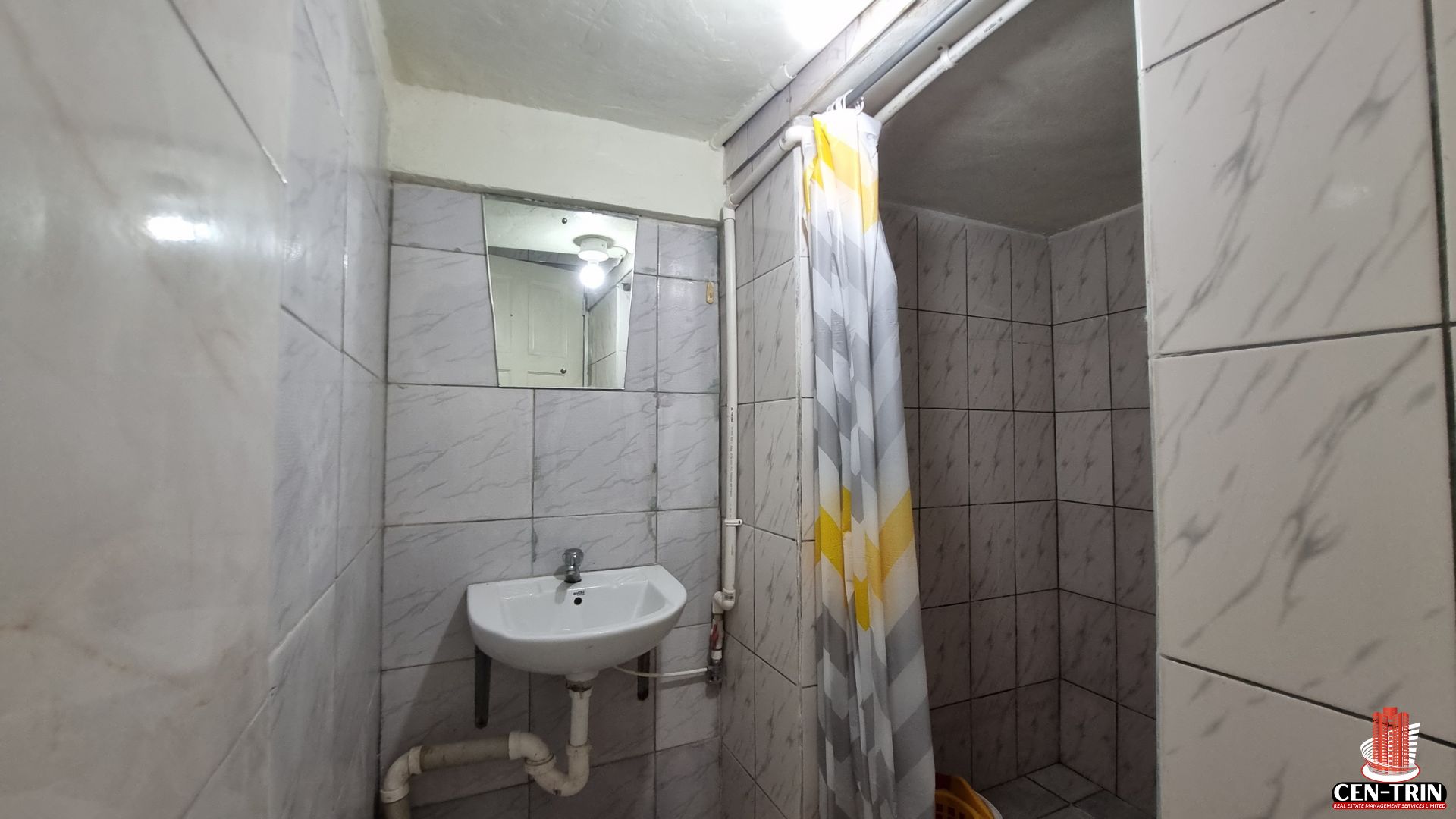 A functional bathroom in a unit of this Home For Sale in Trinidad, featuring a sink, mirror, and shower with curtain, suitable for semi furnished rental setups and a strong rental investment.