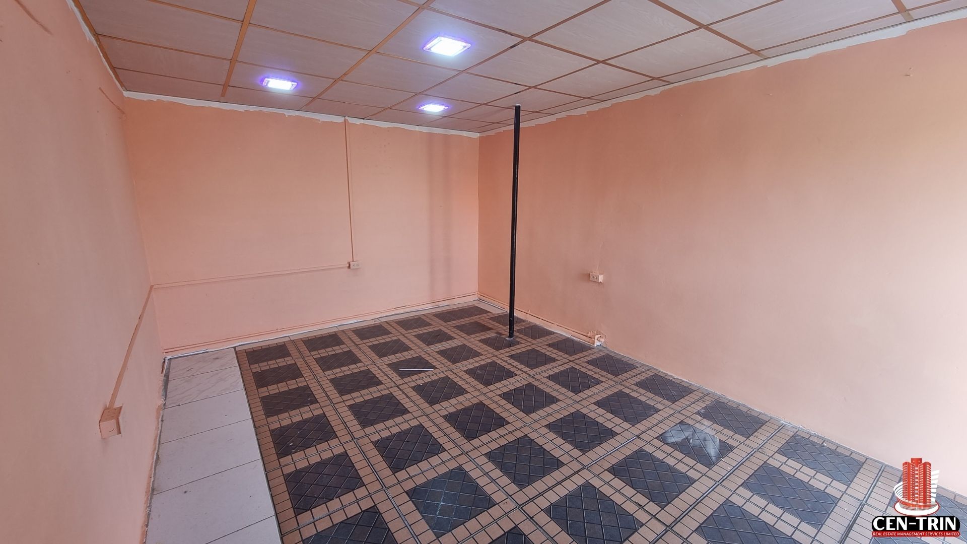 A corner view of the empty commercial rental space on Chin Chin Road, showing the tiled floor, clean walls, and a central pole.