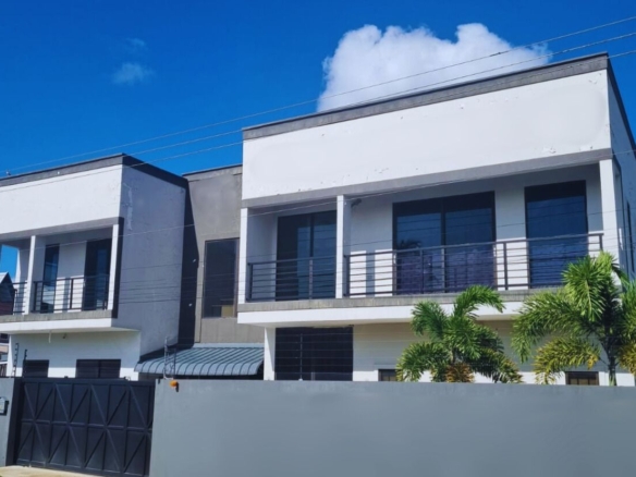Rental for Young Professionals in Trinidad - Barataria 2 Modern apartment building in Barataria, Trinidad, showing a secure compound with an automatic black gate, electric fence, and high-security perimeter. barataria apartment for rent